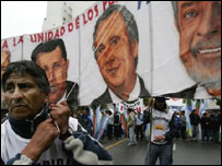 Manifestante exibe cartaz pedindo a integração latino-americana com imagens dos líderes Fidel Castro, de Cuba, Hugo Chávez, da Venezuela, Néstor Kirchner, da Argentina, e o presidente Lula