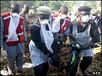 امدادگران جسد يکی از قربانيان سانحه سقوط هواپيما را جابه جا می کنند