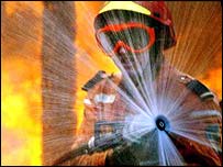 Bombeiro combate o fogo usando mangueira