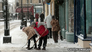 People clearing street outside shops