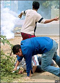 Manifestante joga pedra e homem cai no chão ferido