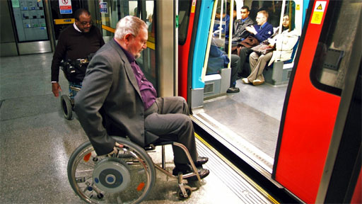 Two wheelchair users boarding a tube train