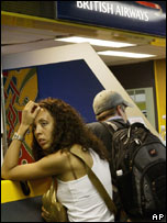 Passengers wait at a British Airways desk, at the Milan Linate airport, Italy