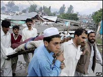 Paquistanteses carregam corpo de vítima do terremoto