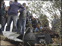 Pessoas observam equipamento deixado por soldado em Gaza