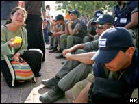 Mulher chora ao lado de policiais no assentamento de Neve Dekalim, em Gaza