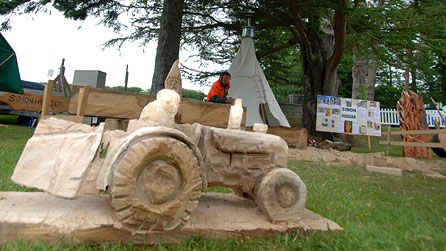 A small chainsaw carved wooden tractor.
