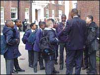 School pupils talk to teacher during breaks