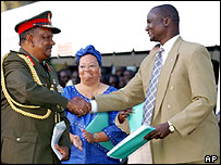 مذاکره کننده شورشيان (راست) و دولت دست می دهند