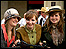 Three girls dressed up with old-fashioned cycles