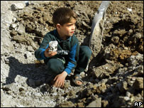 Criança brinca em buraco feito por bomba em Bagdá
