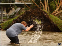 Moradora da Flórida tenta limpar bueiros entupidos em inundação provocada pelo Wilma