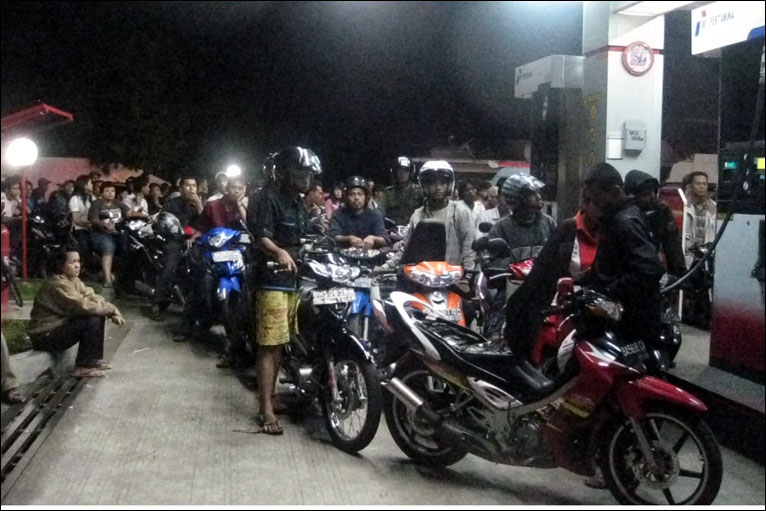 Warga antri membeli BBM untuk kendaraan mereka di SPBU yang masih berfungsi.