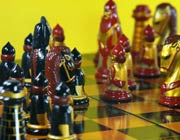 Chess pieces, decorated in red, gold and black, in the middle of a game