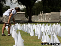 O femeie citind numele victimelor uraganului Katrina inscripţionate pe steaguri
