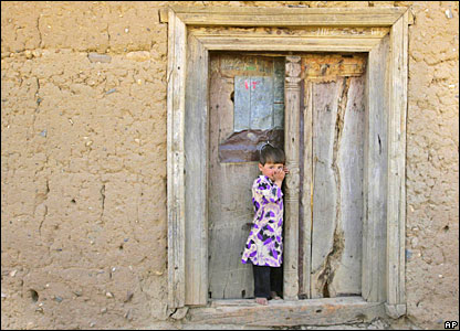 A girl stands near the door of her house in Kabul.
