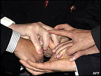 Os seis representantes juntam as mãos simbolicamente no início da reunião 