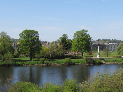 Colour view from Moncrieff Island showing greenery and trees of Perth North Inch, with Victorian and Edwardian terraces behind.