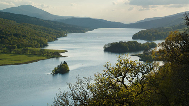 Colour view across the broad expanse of Loch Tummel, with hills around and peak of Schiehallion behind.