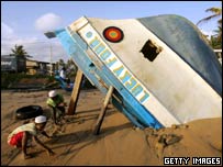 Crianças brincam perto de barco destruído pelo tsunami