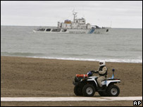 Policial em frente a barco da guarda costeira, em Mar del Plata