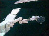 Soichi Noguchi (à dir.), com um giroscópio do lado de fora do Discovery