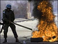 Soldado da ONU enfrenta manifestantes no Haiti (foto: Divulgação/Minustah)