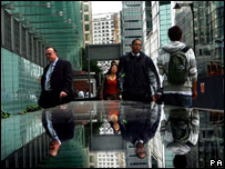 衣着得体的雇员们在摩天玻璃大厦“金丝雀码头”内办公