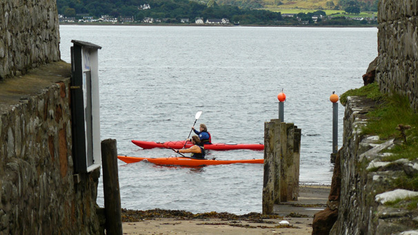 Sea kayakers pass the pier at the Holy Isle