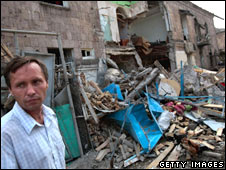 Một người dân đứng cạnh khu căn hộ bị bom Nga đánh đổ