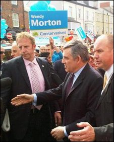 Gordon Brown in Tynemouth but with Conservative placards behind