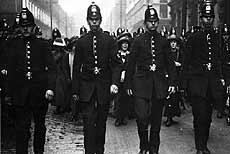 Four policemen controlling women protesting 