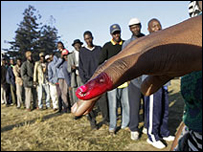 Một cử tri chìa ngón tay dính mực đỏ sau khi bỏ phiếu