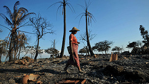 A Rakhine woman walks past burnt houses in Pauktaw on 27th Oct 2012