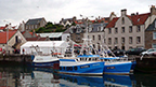 View across Pittenweem habrour to moored boats and the covered fish market.