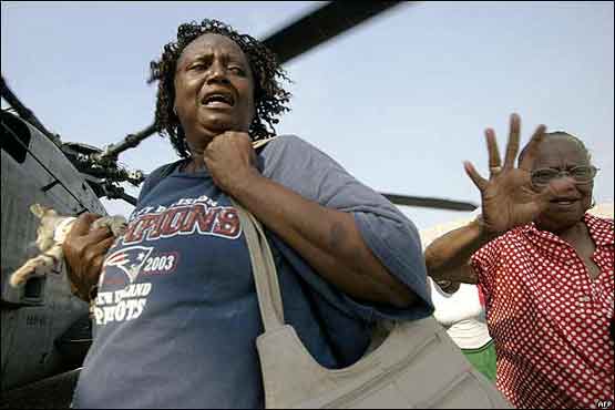 Lidé, evakuovaní do konferenčního centra New Orleans běží k vrtulníkům