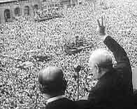 Photograph showing Winston Churchill waving to the gathered crowd on VE Day