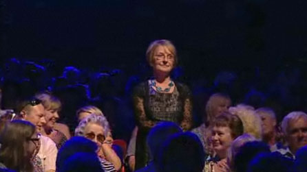 A lady stands in the crowd.