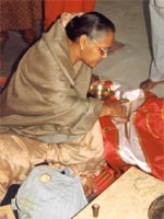 A worshipper kneeling and making offerings to the image of the tirthankara