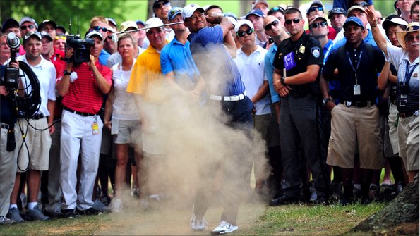 Tiger Woods plays a shot from amongst the trees.