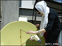 دختری در حال تنظيم آنتن ماهواره