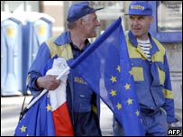 Operário poloneses levam bandeiras da Polônia e da União Européia para decorar o centro de Varsóvia