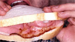 Man eating bacon sandwich
