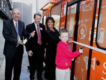 Siôn Jones yn torri'r ruban ar y bws