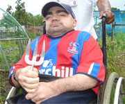Disabled man in wheelchair with garden fork