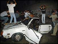 فلسطينی ها لاشه يک خودرو در غزه را محاصره کرده اند