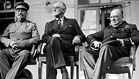 Sitting on the portico of the Russian Embassy at Teheran, Joseph Stalin wears the Order of the Red Star on his tunic; President Roosevelt wears civilian garb and Prime Minister Churchill is dressed in the uniform of an RAF Marshal