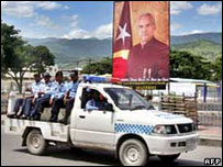 Policiais passam em frente a foto do presidente José Ramos-Horta na capital do Timor Leste, Díli