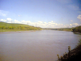 Edrych i fyny'r afon Tywi i gyfeiriad tref Caerfyrddin, ger Glanyfferi. Tynnwyd y llun hwn gan Dylan o Gaerfyrddin o'r trên wrth deithio ar hyd bae Caerfyrddin, tuag at Gaerfyrddin. 