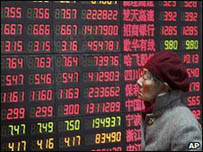 Một cụ bà đang xem bảng chỉ số chứng khoán ở Thượng Hải